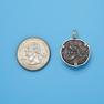 Pendant size next to a Quarter