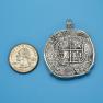 Pendant size next to a Quarter