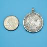 Pendant size next to a Quarter